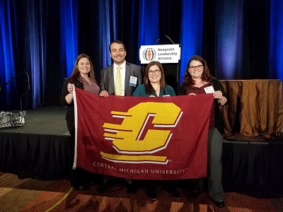 Emma Powell with others behind a CMU flag