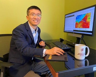 Tao Zheng sitting at his computer