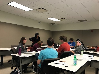 Faculty member Stacey Lim working with students in a classroom.