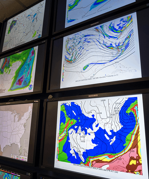 Screens in the Department of Earth and Atmospheric Sciences displaying national weather conditions.