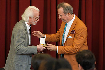 A man receiving an award from another man.