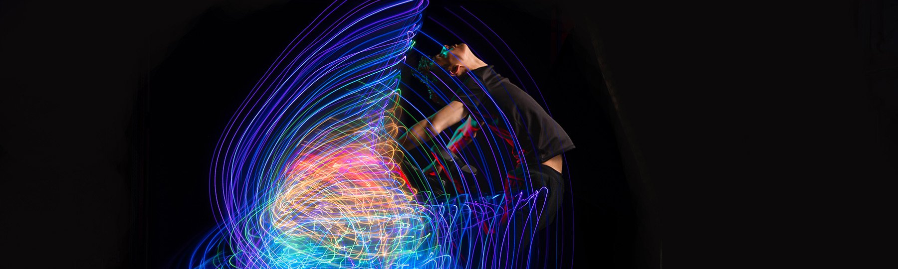 Dance minor student dancing with rainbow cape of lights.