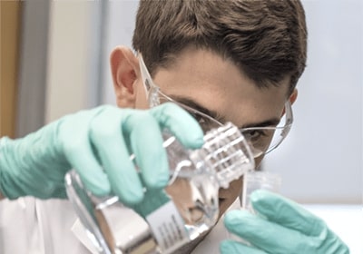 Chemistry lab worker preparing solution.