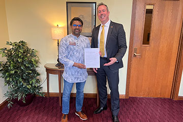 Two men holding a piece of paper.