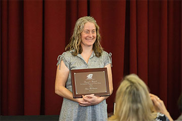 A woman holding a plaque.