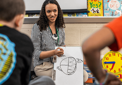 Student teacher showing a drawing to students