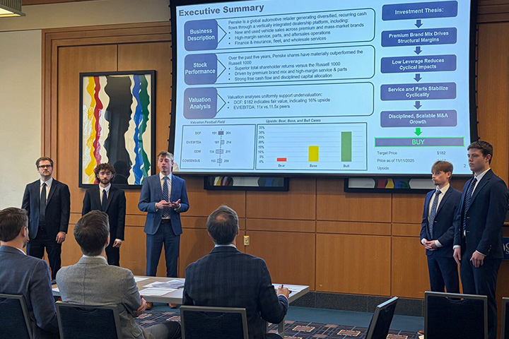 CMU Finance Students Trevor Carnovsky, Nathan Green, Cole Carpenter, John Angerman, and Lucas Pratt stand at the front of a conference room in front of a panel of judges. They are presenting financial recommendations based on months of recommendations.