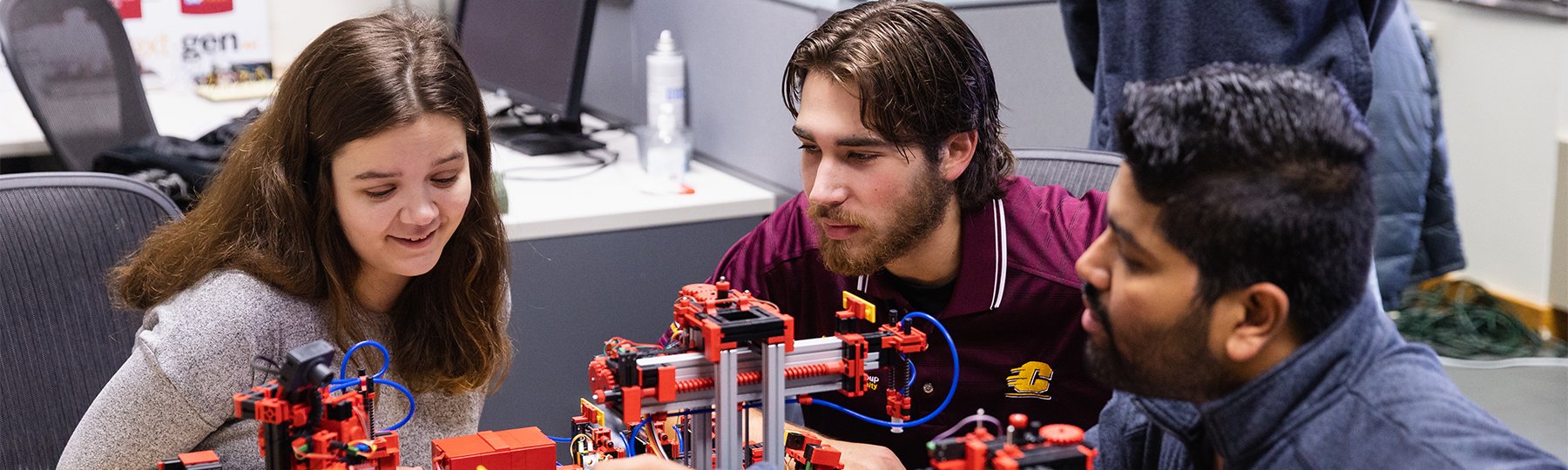 Three students experimenting with a model factory in the SAP NextGen Lab.