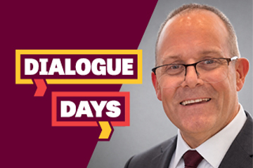 Kevin Goddard wears a gray jacket, white shirt and maroon tie in a Dialogue Days image.