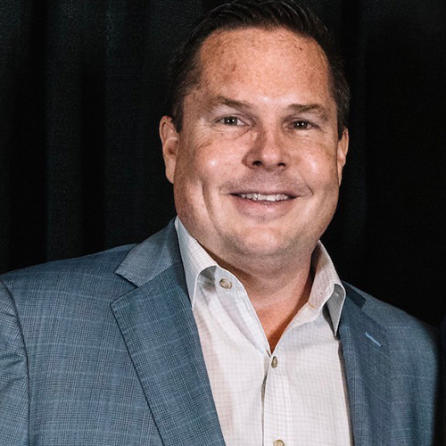 Bob Oros in a gray blazer and light dress shirt, smiling in a professional portrait