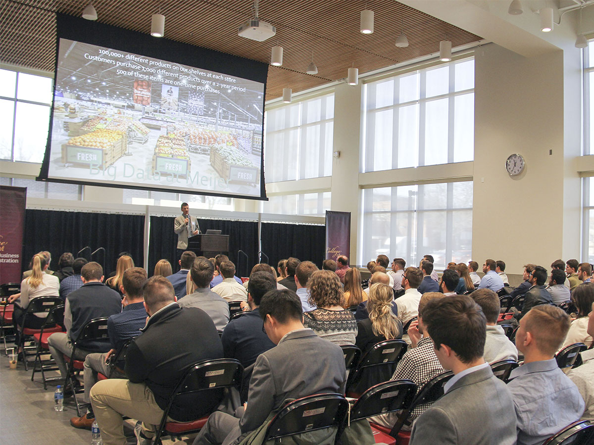 Data analytics conference with a representative from Meijer speaking to a crowd.