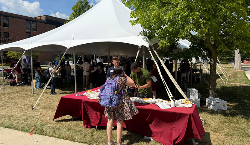 Students gather under a white tent on the Warriner Mall to meet RSOs and discover opportunities to get involved.
