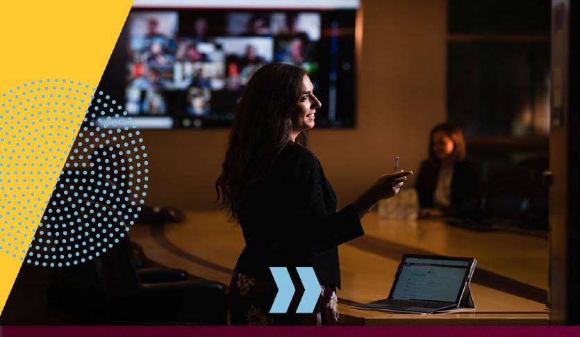 A young woman gives a presentation to a virtual audience in the Plachta conference room.