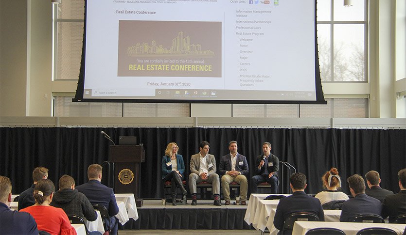 CMU Real estate conference panelists on stage talking to the audience.