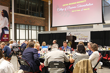 Guests seated at round tables during the Central Michigan University College of Business Administration Hall of Fame and Awards event in the Grawn atrium.