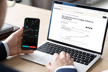 Person viewing a Centralis Brief article on a laptop while monitoring financial market data on a smartphone.