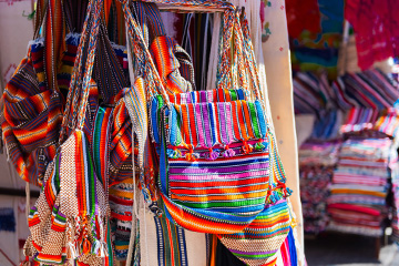 Colorful striped bags hang in an open air market in Paraguay.
