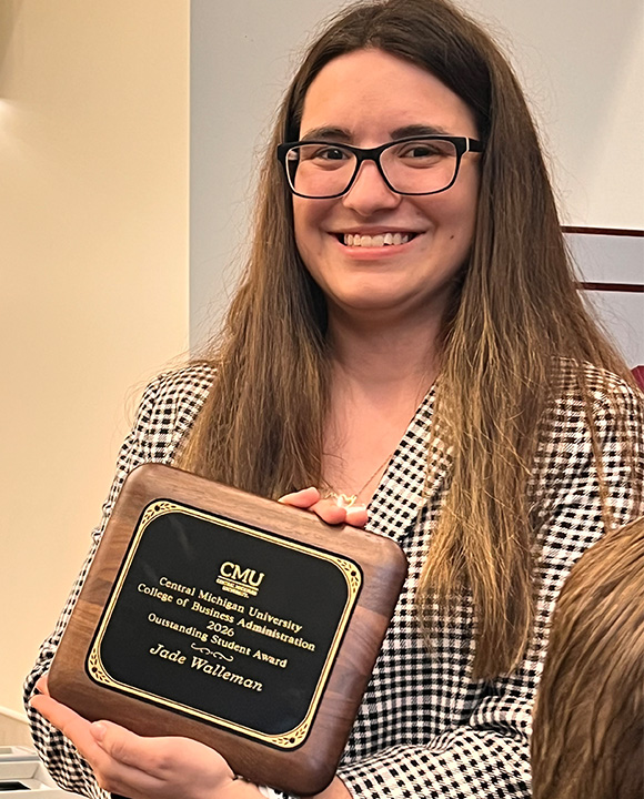 Jade Walleman smiles while holding her Outstanding Student Award from Central Michigan University’s College of Business Administration during an awards event.
