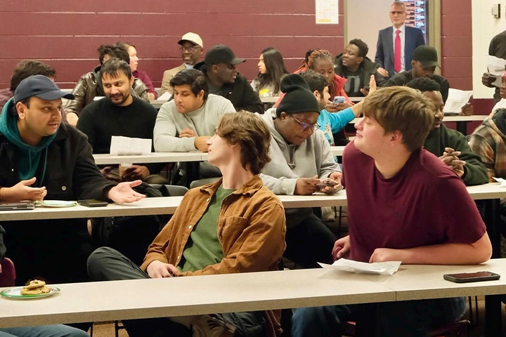 CMU students sit and talk during an American Marketing Association event held in a classroom setting.