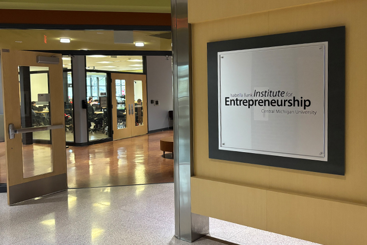 Entrance to the Isabella Bank Institute for Entrepreneurship at Central Michigan University, featuring the institute sign and open doors to collaborative workspace areas.
