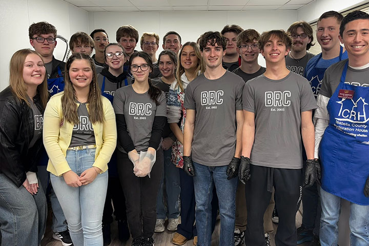 BRC students gather in a kitchen space at the Isabella County Restoration House, preparing to serve a meal.