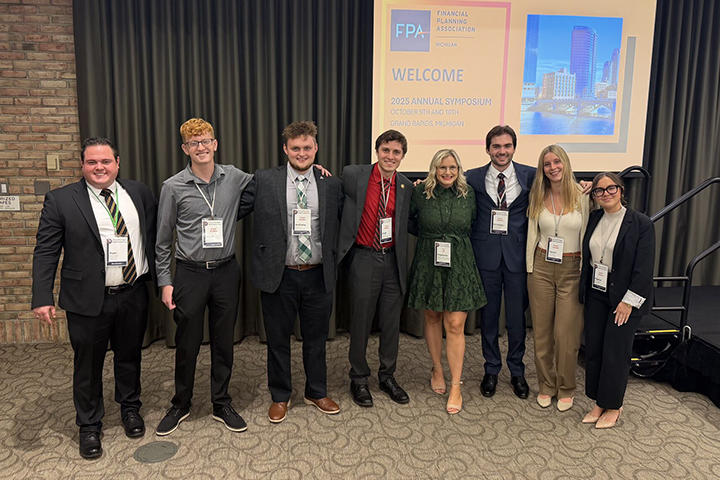 Payton McKay stands on the far right side of the image with members of the Financial Planning Association RSO at the 2025 Financial Planning Association annual symposium. The students are dressed in business professional clothing.