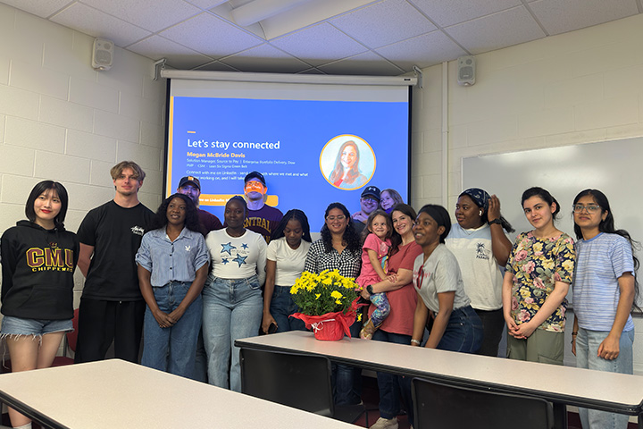 CMU Project Management chapter members pose with guest speaker Megan McBride Davis and other attendees in a classroom following a presentation by the Dow alumna.