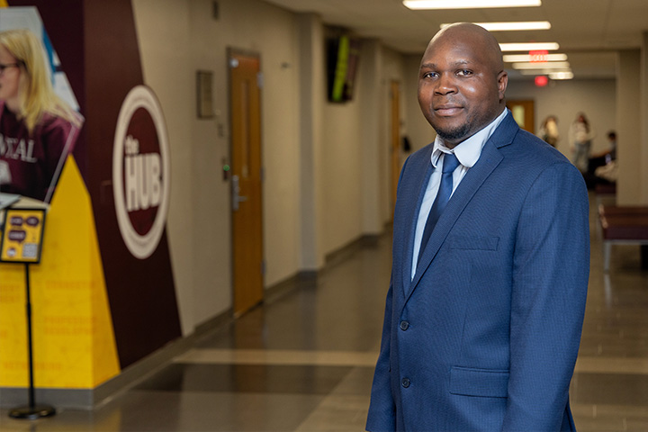 Reuben Chirikure stands in a hallway in Grawn Hall at Central Michigan University.