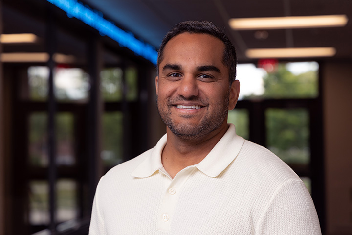 CMU management faculty member Tomas Thundiyil smiles for a portrait inside Grawn Hall.