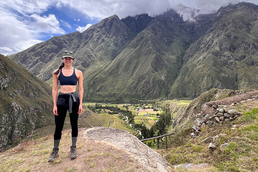 Annie Ludington stands at Machu Picchu in black yoga pants and a black sports bra.