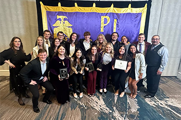 Students in Pi Sigma Epsilon Sales Fraternity posing for group photo with their awards from the national convention.
