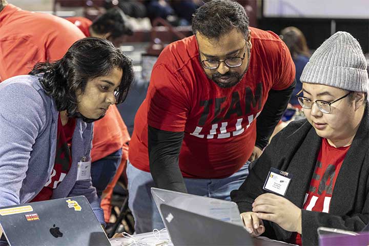 Students huddled around computers at annual ERPsim Competition