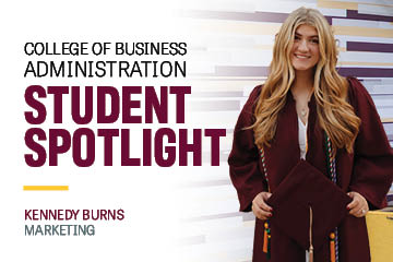 Image text: College of Business Administration Student Spotlight Kennedy Burns Marketing. Image: Kennedy Burns wears a maroon graduation gown and holds her graduation cap in front of her. She has long blond hair with beach wave. She smiles at the camera.