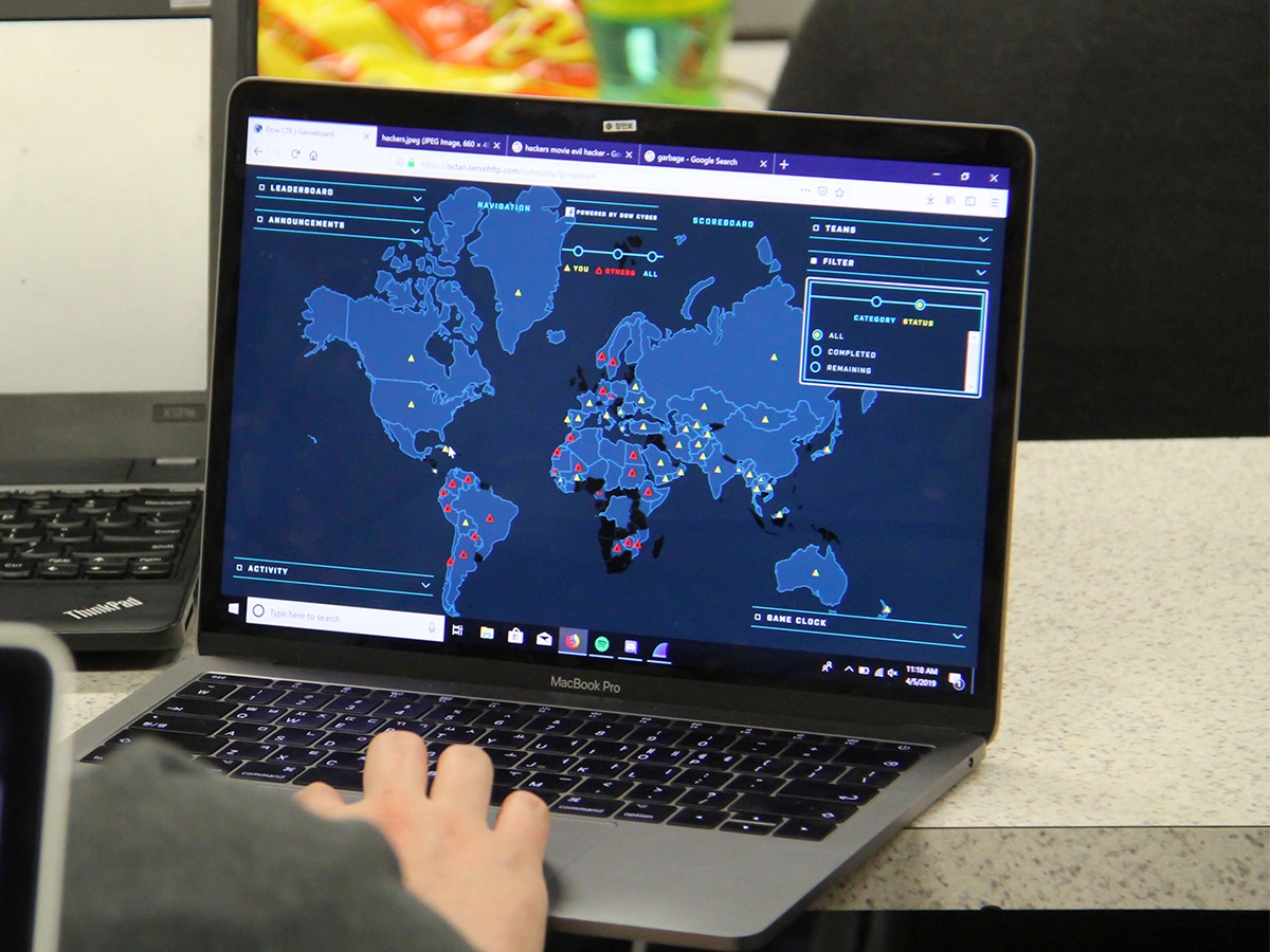 Cybersecurity student exploring a world map on their laptop while playing capture the flag.