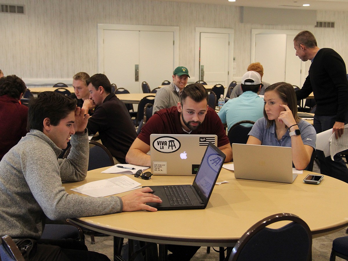 Michigan Finance Scholars Workshop, students sitting along tables with laptops working on case studies