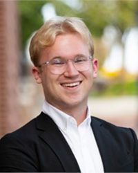 A professional headshot of Ethan Rauschert