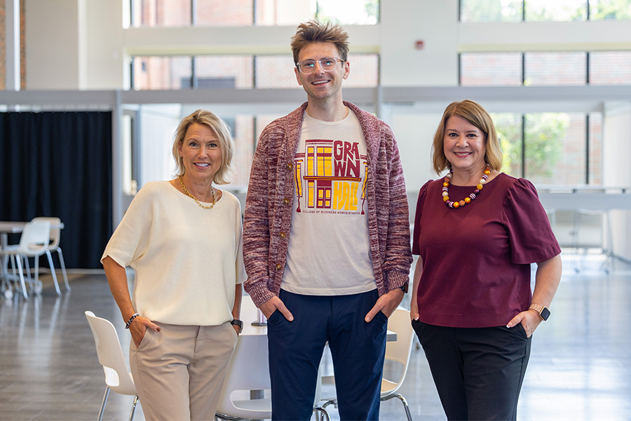 Lori Driessnack, Anthony Niemiec and Amy McGinnis stand together in the Grawn atrium.