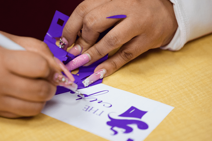 A student trimming a Cricut print.
