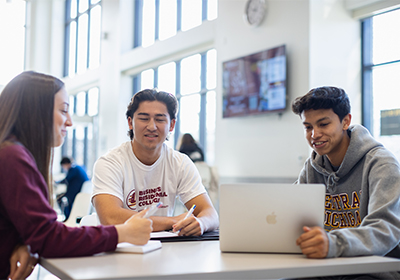 Three CMU students working on a class project in the Grawn Atrium.