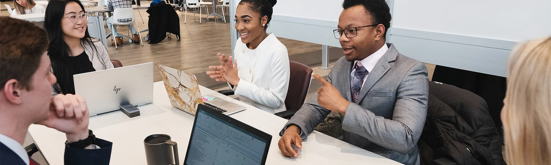 Business students at a conference table discussing topics