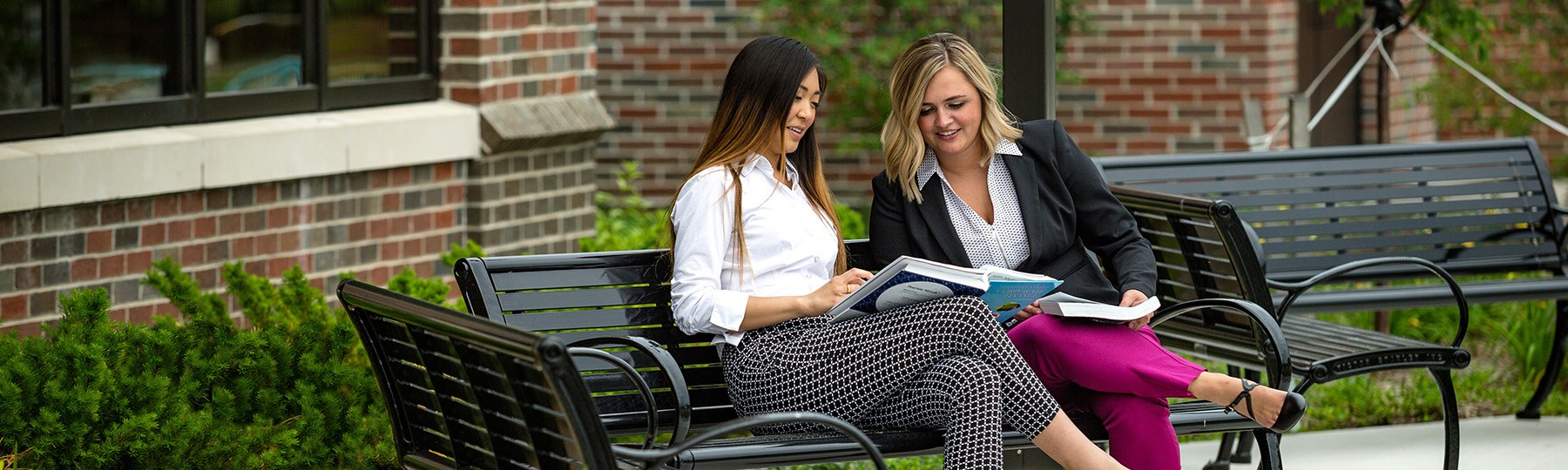 Two people sitting on a bench outdoors