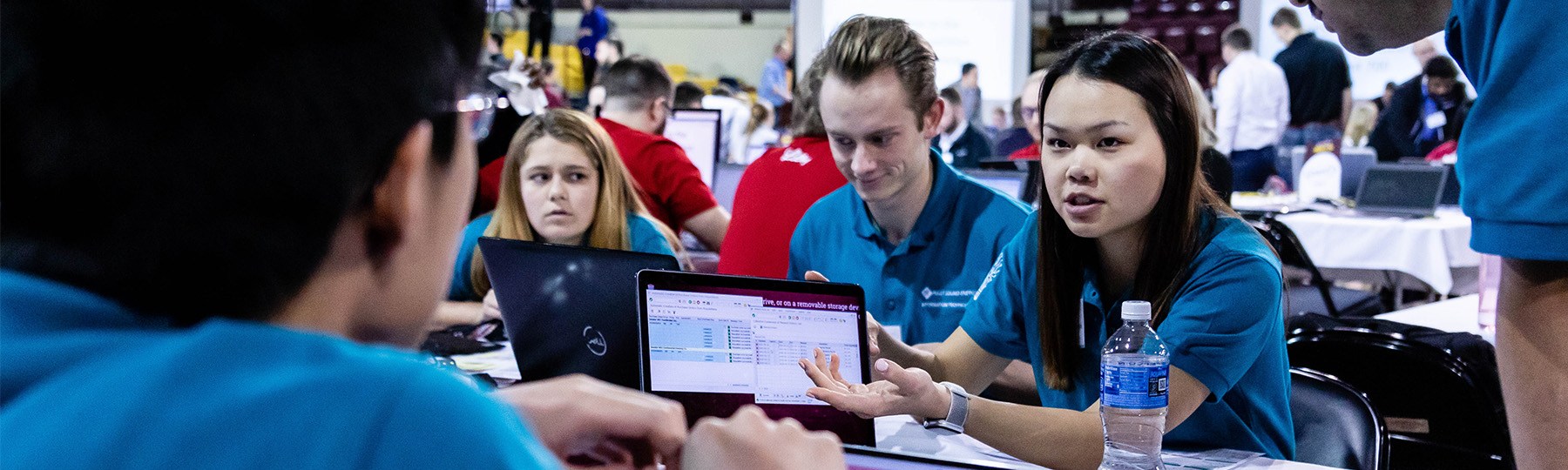Students discussing a topic over a laptop