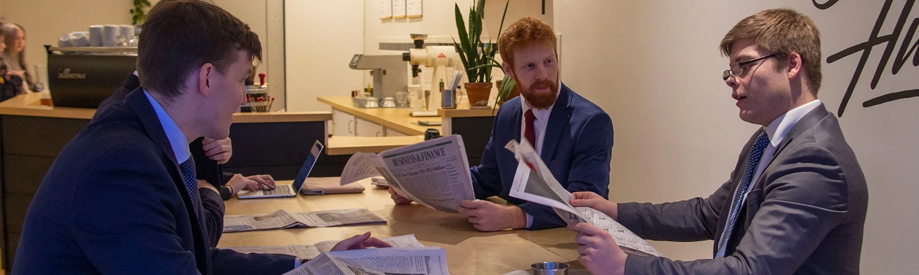 Three people reading newspapers