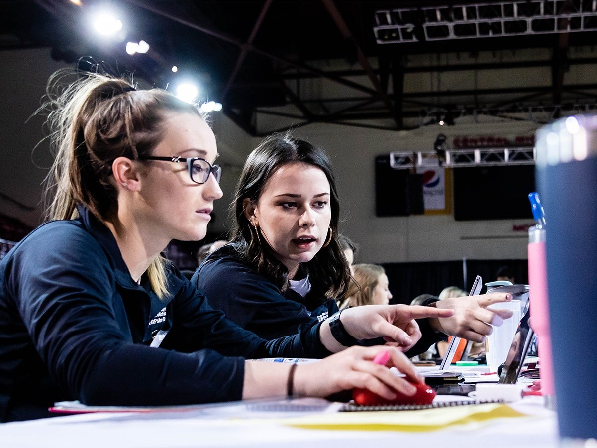 Two female students examining data in SAP while competing in ERPsim.