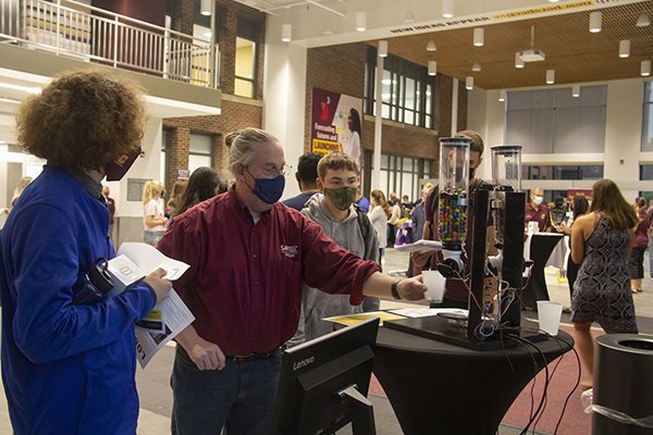 Professor demonstrating SAP Next-Gen Candy Machine at CBA Involvement Fair