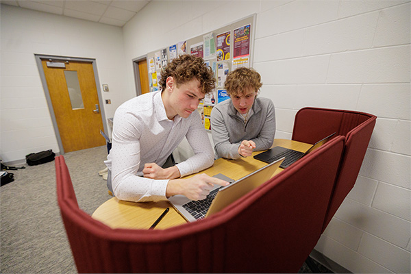 Two students looking at a laptop