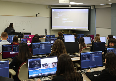 A photo of showing students working in SAP in the computer lab. It's taken from the back of the classroom, which appears full, and you can see their SAP interfaces on their screens.