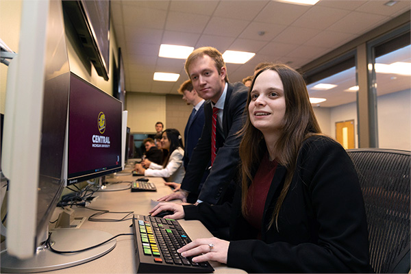 Michigan Finance Scholar students are using the Bloomberg terminals in Grawn Hall. They are smiling and are engaged with the materials they are researching.