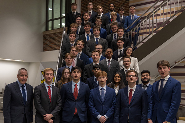 Students and their faculty advisor from the Michigan Finance Scholars program pose on the grand staircase in Grawn Hall.