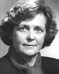 A black and white photo of a woman with short hair wearing a scarf and blazer.
